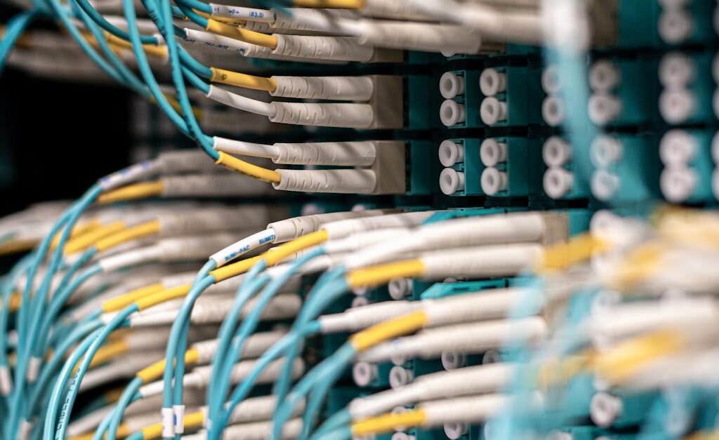 Rows of blue cables and wires plugged into server patch panel located in modern data center framework